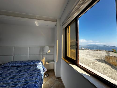 a bedroom with a bed and a window with a view at Re Vincy - Affittacamere in Bacoli