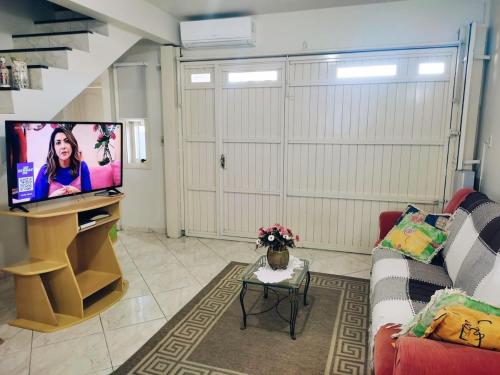 een woonkamer met een bank en een flatscreen-tv bij Hospede-se aqui! Casa Inteira em Santa Clara do Sul in Santa Clara do Sul