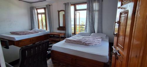 a room with two beds and a mirror at Fikkalaygaon Homestay By AALEKH in Kalimpong