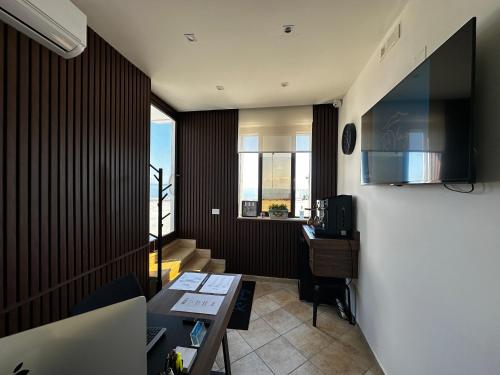 a living room with a table and a kitchen at Re Vincy - Affittacamere in Bacoli