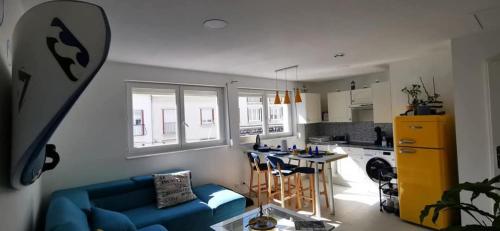 a living room with a blue couch and a kitchen at Les bulles marine in Calais