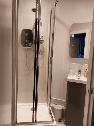 a shower with a glass door in a bathroom at East Claremont Guest House in Edinburgh