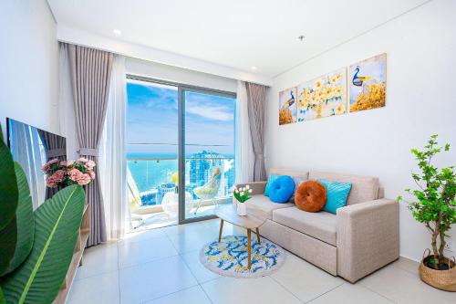 a living room with a couch and a view of the ocean at Cloud Nine The Song Vung Tau Homestay in Vung Tau