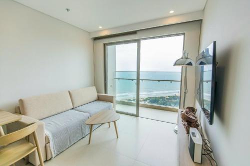 a living room with a couch and a view of the ocean at Cloud Nine The Song Vung Tau Homestay in Vung Tau