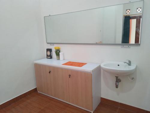 a bathroom with a sink and a mirror at Bantul Syariah Homestay in Bantul