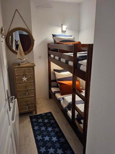 - une chambre avec des lits superposés, un miroir et une commode dans l'établissement T2 Pornichet 4 pers 50m plage, à Pornichet