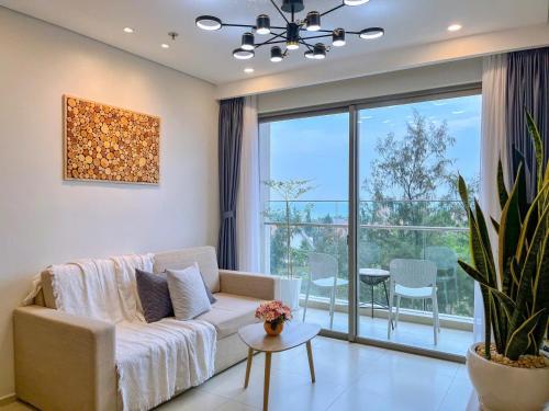 a living room with a couch and a large window at Cloud Nine The Song Vung Tau Homestay in Vung Tau