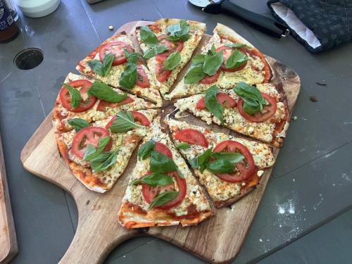 a pizza sitting on top of a wooden cutting board at Mngazana Hideaway in Port St Johns