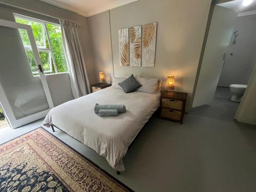 a bedroom with a bed with two pillows and a window at Mngazana Hideaway in Port St Johns