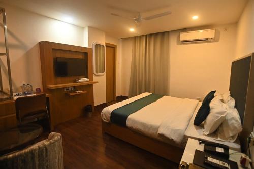 a hotel room with a bed and a desk at Hotel Prag Continental in Guwahati