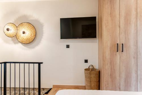 a bedroom with a bed and a tv on a wall at Casa Myrtēssa in Myrtos