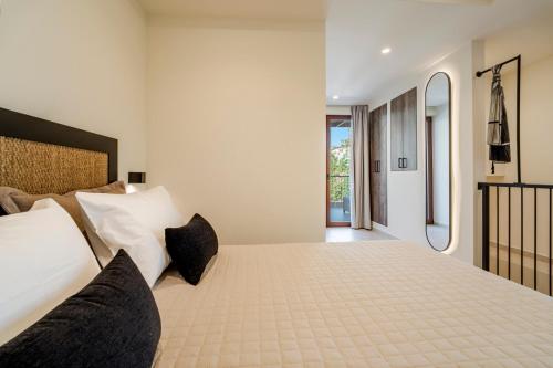 a bedroom with a large bed with black pillows at Casa Myrtēssa in Myrtos