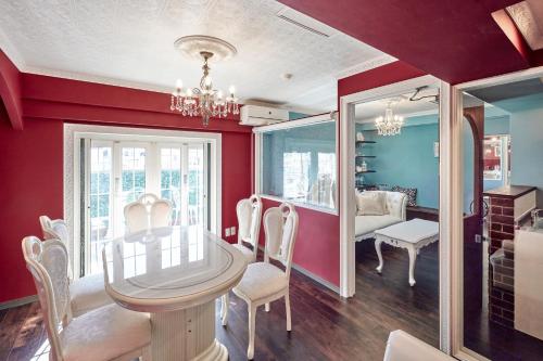 a dining room with red walls and a table and chairs at Spacious 80sqm Apt near Shibuya Crossing, 8 min walk to Shibuya Station in Tokyo