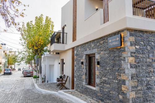 a stone building with a sign on it on a street at Casa Myrtēssa in Myrtos