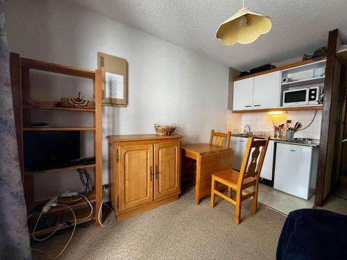 eine kleine Küche mit einem Tisch und einem Stuhl und einer Theke in der Unterkunft Apartemet montagne La pagne Motalbert au pied des pistes location semane de samadi a samedi in Montalbert