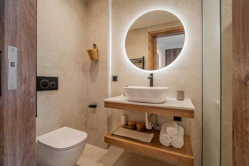 a bathroom with a sink and a toilet and a mirror at Casa Myrtēssa in Myrtos