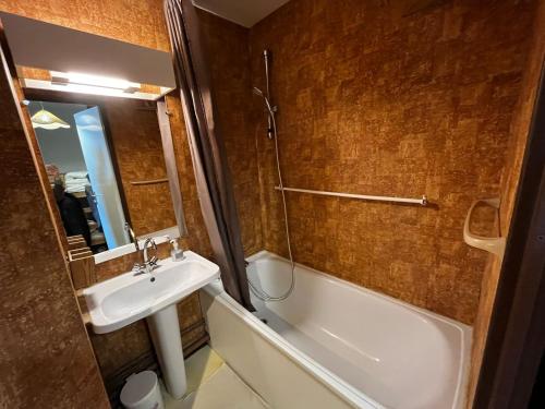 ein Badezimmer mit Waschbecken, Badewanne, Toilette und Spiegel in der Unterkunft Apartemet montagne La pagne Motalbert au pied des pistes location semane de samadi a samedi in Montalbert