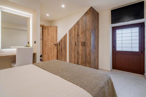 a bedroom with a large bed and a sliding door at Casa Myrtēssa in Myrtos