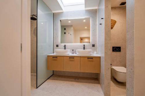 a bathroom with two sinks and a mirror at Casa Myrtēssa in Myrtos