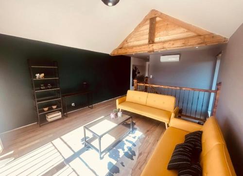 un salon avec un canapé jaune et une table dans l'établissement La cour de Ferme, à Coume