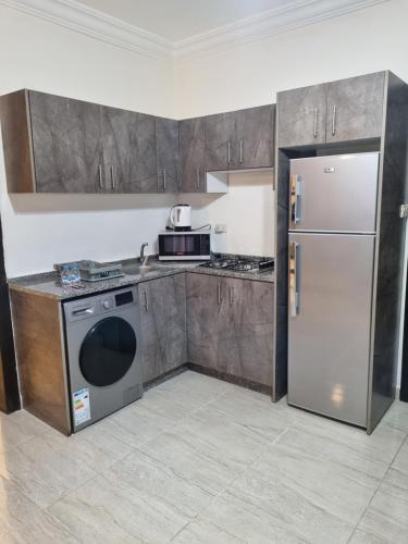 a kitchen with stainless steel appliances and a refrigerator at unique one bedroom at abdoun 005 in Amman