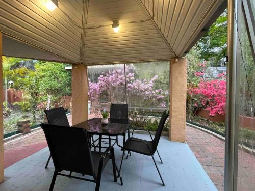 a patio with a table and chairs and flowers at Hideaway Lodge in Springwood