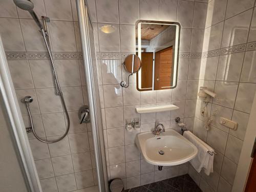 a bathroom with a sink and a shower with a mirror at Appartement Pension St. Sebastian in Pettneu am Arlberg