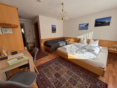 a bedroom with a bed and a desk and a table at Appartement Pension St. Sebastian in Pettneu am Arlberg