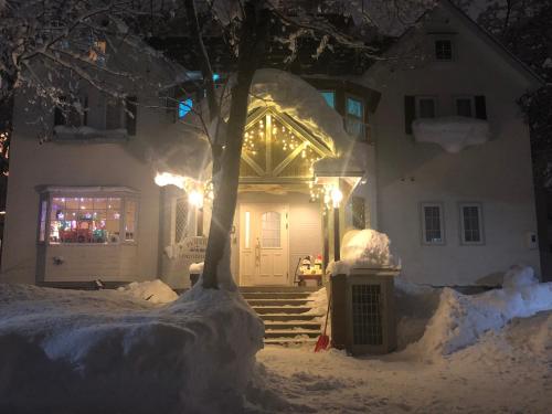 a house with christmas lights on the front door at Pension Locomotion in Kutchan