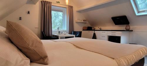 a bedroom with a bed and a sink and a window at Slapen bij Jansz in Kamperland