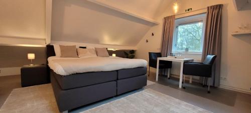 a bedroom with a bed and a desk and a window at Slapen bij Jansz in Kamperland