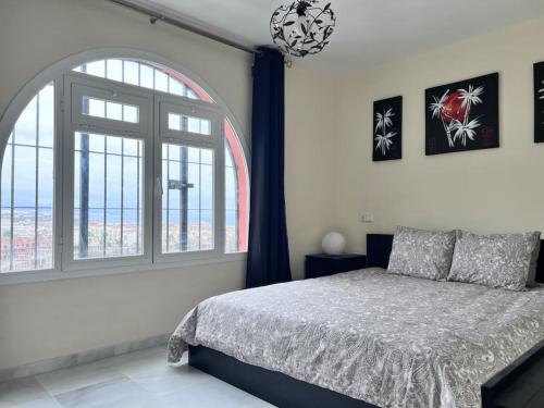 a bedroom with a bed and a large window at Luxury town House with private garden in Duquesa in San Luis de Sabinillas