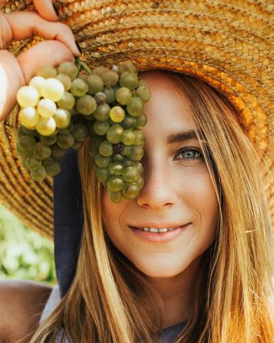 a woman wearing a straw hat with grapes on her head at Peralta Villas Boutique Adults Only in Renau
