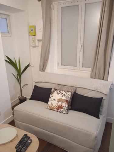 un canapé dans un salon avec une fenêtre dans l'établissement Paris Center, 1BR-4P, Sentier, à Paris