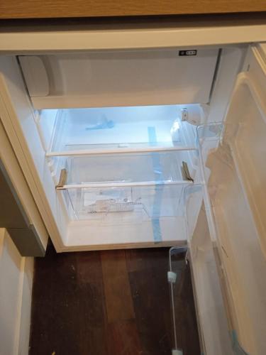 un réfrigérateur vide avec sa porte ouverte dans une cuisine dans l'établissement Paris Center, 1BR-4P, Sentier, à Paris