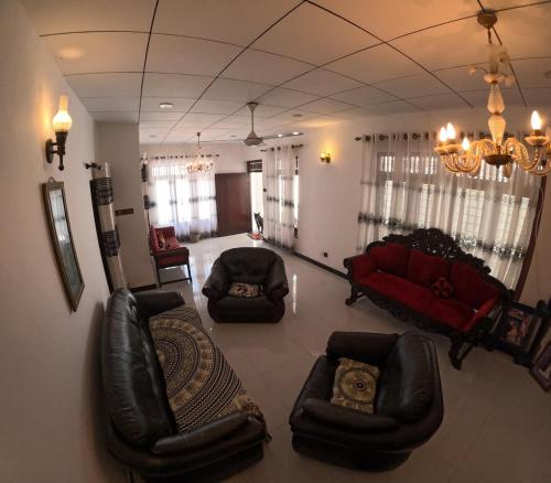 - un salon avec des fauteuils en cuir et un canapé rouge dans l'établissement Cinnamon Villa Weligama, à Weligama