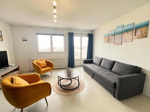un salon avec un canapé et deux chaises dans l'établissement Le Phare, à Calais