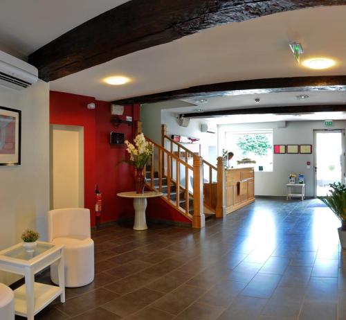 - un salon avec un escalier et un hall dans l'établissement Hôtel Burgevin, à Sully-sur-Loire