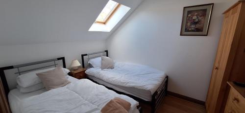 two beds in a small room with a window at 2 Bed Cottage - sleeps 4 - Garden Parking Wifi in Swansea