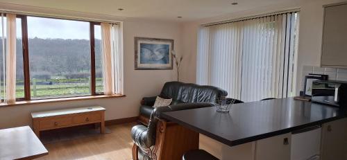 a living room with a table and a leather chair at 2 Bed Cottage - sleeps 4 - Garden Parking Wifi in Swansea