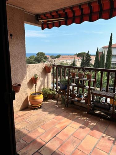 d'une terrasse avec un balcon orné de plantes en pot. dans l'établissement Le Ciel Bleu - vue mer, toute à pied plage et commerce, à Fréjus