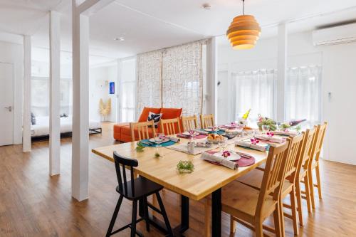 a dining room with a wooden table and chairs at プライベートサウナでととのうpono 118は今帰仁村にあるお庭付き一棟貸 in Nago