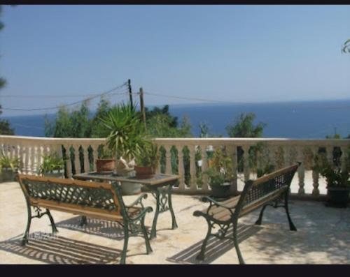 a patio with two benches and a table on a balcony at Rena Apartments Vasilikos Zante in Xirokástellon