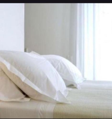 a group of pillows on a bed with a window at Rena Apartments Vasilikos Zante in Xirokástellon