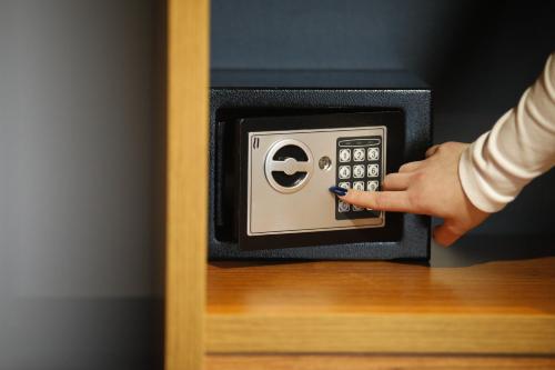 a person is pressing a button on a safe at Olivia's Hill Resort in Durrës