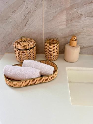 two baskets of towels and a vase on a counter at Stylish penthouse with panoramic views at Icon Park in Kamala Beach