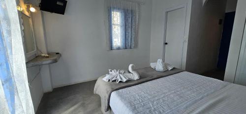 a bedroom with a bed with white sheets and a window at Hotel Pleasure Black Beach Perissa Santorini in Perissa