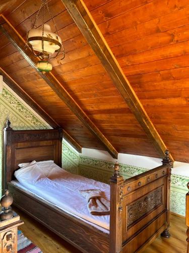 a bed in a room with a wooden ceiling at Pansion Sašin Salaš 40m2 in Rumenka
