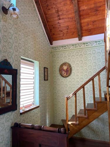 a staircase in a room with a window and a stair case at Pansion Sašin Salaš 40m2 in Rumenka