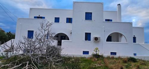 a white building sitting on top of a hill at Hotel Pleasure Black Beach Perissa Santorini in Perissa